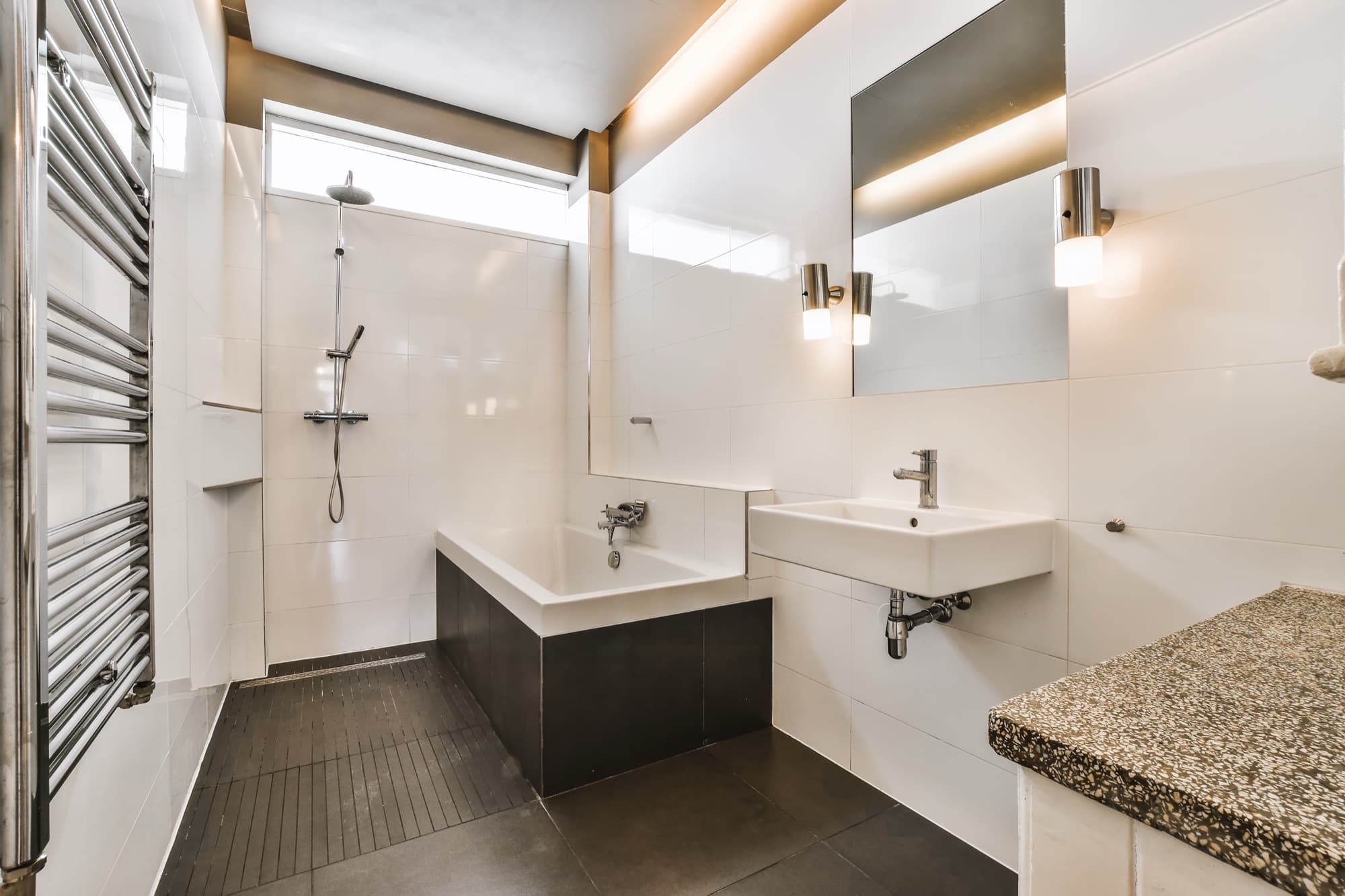 Tiled bathroom with a walk-in shower area, bath, wall-hung basin and chrome fittings