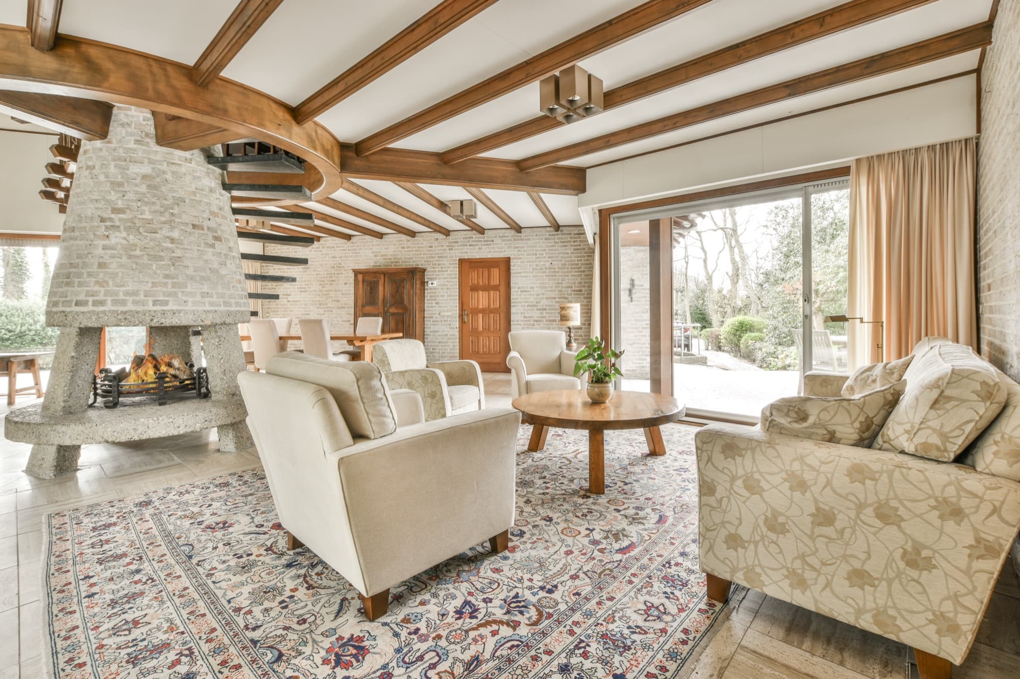 Beamed living room with an open fire, exposed brick walls and sliding doors onto the garden